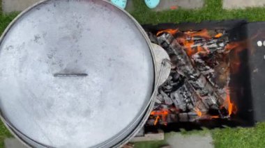 The process of cooking traditional Uzbek pilaf. Close-up footage of a man cooking pilaf in a cauldron on a fire. Video 4k.