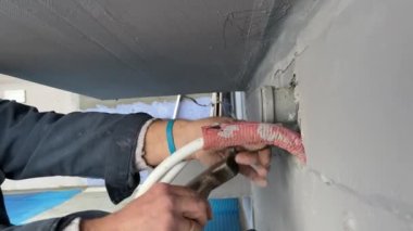 Plumbing work on installing the outlet of cold and hot water from the wall to connect the faucet to the sink. 4k video footage of construction work inside the building