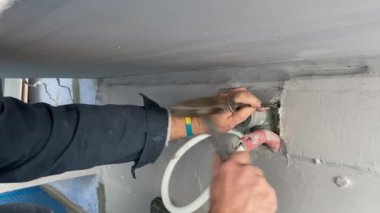Plumbing work on installing the outlet of cold and hot water from the wall to connect the faucet to the sink. 4k video footage of construction work inside the building