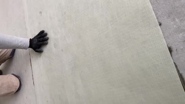 Строитель Приклеивает Синтетическую Нетканую Ткань Клею Плитки Перед Укладкой Плитки — стоковое видео