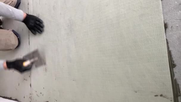 Строитель Приклеивает Синтетическую Нетканую Ткань Клею Плитки Перед Укладкой Плитки — стоковое видео