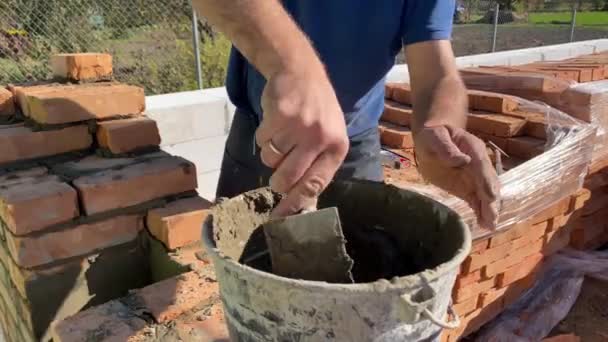 Felvétel Egy Építőmunkásról Aki Téglafalazatot Végez Egy Építkezésen Kőműves Habarccsal — Stock videók