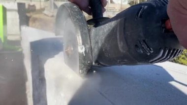 4k video footage of a builder cutting a foam block with a grinder at a construction site for a reinforcement device. Construction of a private house from a gas block, foam block.