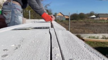 4k video footage of a male builder removing pieces of foam block from a cut strobe. Construction of a private house from a gas block, foam block.