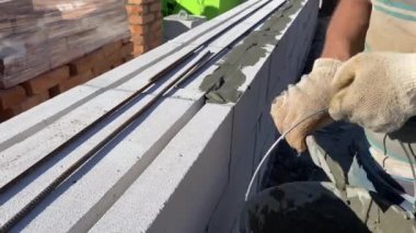 Özel bir evin inşaat alanında köpük blok duvarların metal bir çubukla güçlendirilmesi. 4k video kaydı