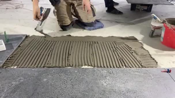 4K视频镜头 将一个大的宽格式的瓷砖放在安装的迫击炮上 瓷砖铺在水泥砂浆表面粘贴瓷砖 — 图库视频影像