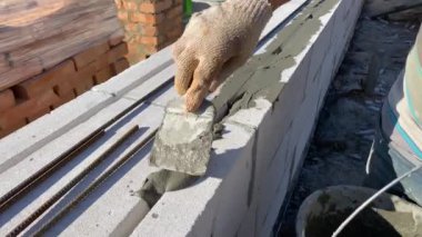 Reinforcement of foam block walls with a metal rod at the construction site of a private house. 4k video footage
