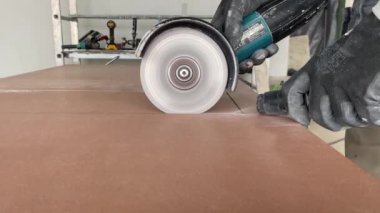 4k video footage of taking measurements for further cutting tiles using a diamond cutter. Laying tiles by a professional tiler in a modern interior.