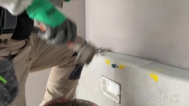 Yükselen bir havan mermisinin üzerine geniş formatlı fayans döşeme görüntüsü 4K. Bir yüzeye fayans yapıştırmak için çimento harcı döşeyen Tiler.