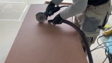 4k video footage of taking measurements for further cutting tiles using a diamond cutter. Laying tiles by a professional tiler in a modern interior.