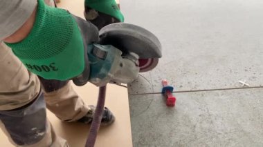 4k video footage of taking measurements for further cutting tiles using a diamond cutter. Laying tiles by a professional tiler in a modern interior.