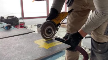 4k video footage of taking measurements for further cutting tiles using a diamond cutter. Laying tiles by a professional tiler in a modern interior.