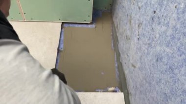 4k video footage of laying a large wide-format tile on a mounting mortar. Tiler laying tiles on cement mortar for gluing tiles on a surface with a floor heating system