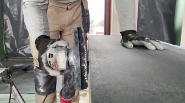 Tamirat işi. Kırk beş derecelik kiremit kesiklerinin 4K video görüntüsü. İnşaatçı tiler büyük bir porselen taş kaplamayı öğütücüyle kesiyor.