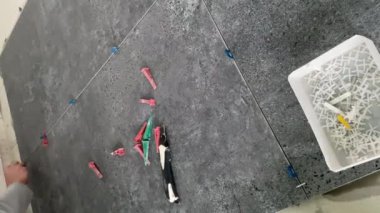 4k video footage of laying a large wide-format tile on a mounting mortar. Tiler laying tiles on cement mortar for gluing tiles on a surface