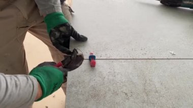 4k video footage of taking measurements for further cutting tiles using a diamond cutter. Laying tiles by a professional tiler in a modern interior.