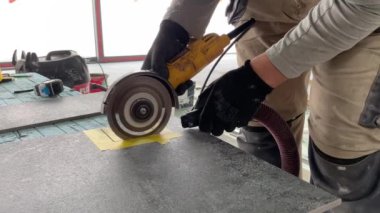 4k video footage of taking measurements for further cutting tiles using a diamond cutter. Laying tiles by a professional tiler in a modern interior.