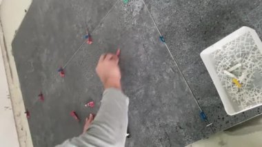 4k video footage of laying a large wide-format tile on a mounting mortar. Tiler laying tiles on cement mortar for gluing tiles on a surface