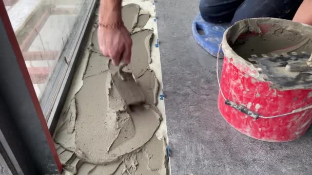 4K视频镜头 将一个大的宽格式的瓷砖放在安装的迫击炮上 瓷砖铺在水泥砂浆表面粘贴瓷砖 — 图库视频影像