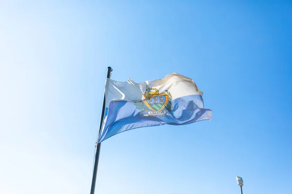 stock image Flag of San Marino in front of blue sky fluttering in the wind