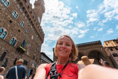 Floransa 'da, Palazzo Vecchio yakınlarında fotoğraf çeken bir kadın. Seyahat eden İtalyan simgeleri kavramı.