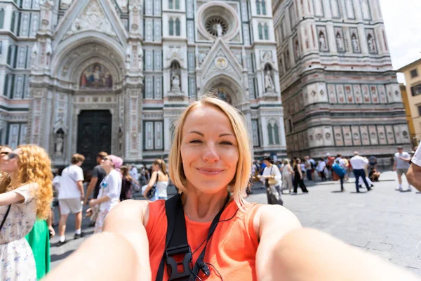 イタリア フィレンツェのサンタ マリア フィオーレ大聖堂を背景に写真を撮る若い女性 ストック写真