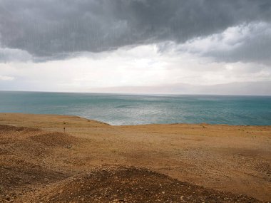 Ölü Deniz üzerinde yağmur ve bulutlar.