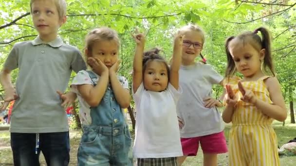 Χαμογελώντας Ομάδα Παιδιών Στο Πάρκο Μιλώντας Μεταξύ Τους — Αρχείο Βίντεο