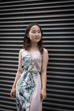 Genç kız gülümsüyor ve elbise giyiyor.