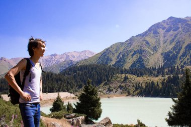 Yaz günü dağın tepesinde yürüyüş yapan biri.