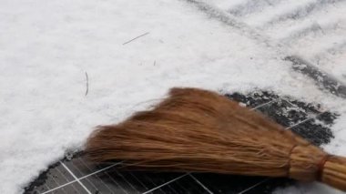 Kışın güneş panelinden süpürgeyle kar ve su çıkarmak.