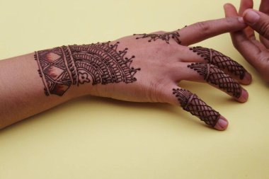 Henna mehendi dövmesinde elle boyanmış bir resim. Hint Mehendi kutlaması. Kına başvurusu ve ritüeller. Hintli gelin ve nedime kına sanatını gösteriyor