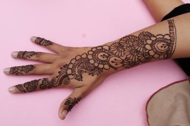 Henna mehendi dövmesinde elle boyanmış bir resim. Hint Mehendi kutlaması. Kına başvurusu ve ritüeller. Hintli gelin ve nedime kına sanatını gösteriyor