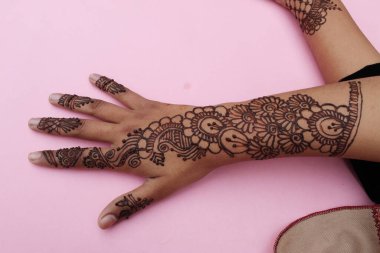 Henna mehendi dövmesinde elle boyanmış bir resim. Hint Mehendi kutlaması. Kına başvurusu ve ritüeller. Hintli gelin ve nedime kına sanatını gösteriyor