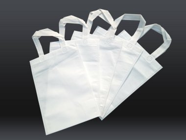 white color non woven bags on black background. Reduce reuse recycle Bags. Few ECO friendly fabric bags. clipart