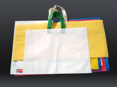 Siyah arka planda dokumasız renkli çantalar. Geri dönüşüm torbalarını azalt. Birkaç ECO dostu kumaş torbası..