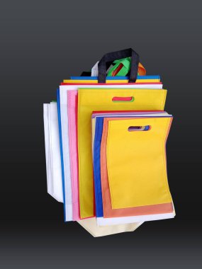 Siyah arka planda dokumasız renkli çantalar. Geri dönüşüm torbalarını azalt. Birkaç ECO dostu kumaş torbası..