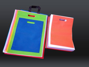 Siyah arka planda dokumasız renkli çantalar. Geri dönüşüm torbalarını azalt. Birkaç ECO dostu kumaş torbası..