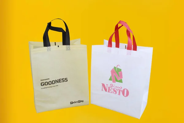 Assorted Color Non-Woven Fabric Shopping Bags isolated on yellow background. Tote Eco-Friendly Bags. Climate change disposable bags with yellow color background