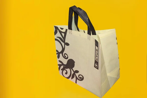 Assorted Color Non-Woven Fabric Shopping Bags isolated on yellow background. Tote Eco-Friendly Bags. Climate change disposable bags with yellow color background