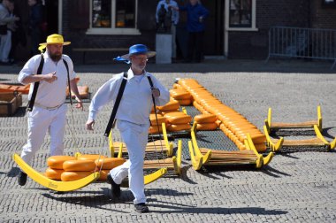 Alkmaar, Hollanda - 22 Nisan 2022: Bu tüccar pazarının Alkmaar, Hollanda 'daki geleneksel Peynir Pazarı' nda nasıl işlediğinin gösterimi sırasında kimliği belirsiz kişiler