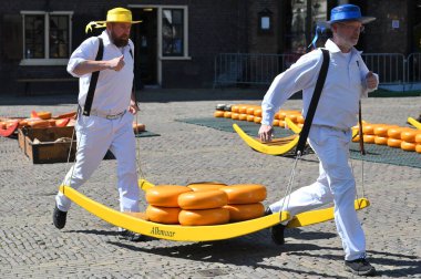 Alkmaar, Hollanda - 22 Nisan 2022: Bu tüccar pazarının Alkmaar, Hollanda 'daki geleneksel Peynir Pazarı' nda nasıl işlediğinin gösterimi sırasında kimliği belirsiz kişiler