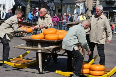 Alkmaar, Hollanda - 22 Nisan 2022: Bu tüccar pazarının Alkmaar, Hollanda 'daki geleneksel Peynir Pazarı' nda nasıl işlediğinin gösterimi sırasında kimliği belirsiz kişiler