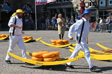 Alkmaar, Hollanda - 22 Nisan 2022: Bu tüccar pazarının Alkmaar, Hollanda 'daki geleneksel Peynir Pazarı' nda nasıl işlediğinin gösterimi sırasında kimliği belirsiz kişiler