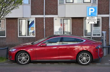 Haarlem, Hollanda - 21 Nisan 2022: Tesla arabası şarj noktasında. Haarlem, Hollanda 'da bir şehirdir.