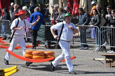 Alkmaar, Hollanda - 22 Nisan 2022: Bu tüccar pazarının Alkmaar, Hollanda 'daki geleneksel Peynir Pazarı' nda nasıl işlediğinin gösterimi sırasında kimliği belirsiz kişiler