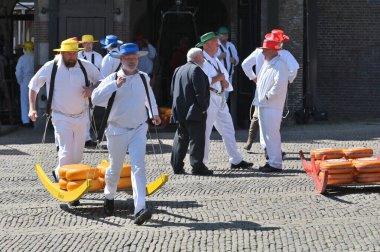 Alkmaar, Hollanda - 22 Nisan 2022: Bu tüccar pazarının Alkmaar, Hollanda 'daki geleneksel Peynir Pazarı' nda nasıl işlediğinin gösterimi sırasında kimliği belirsiz kişiler
