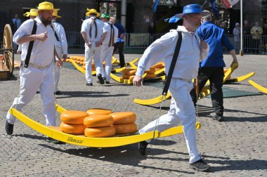 Alkmaar, Hollanda - 22 Nisan 2022: Bu tüccar pazarının Alkmaar, Hollanda 'daki geleneksel Peynir Pazarı' nda nasıl işlediğinin gösterimi sırasında kimliği belirsiz kişiler