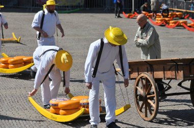 Alkmaar, Hollanda - 22 Nisan 2022: Bu tüccar pazarının Alkmaar, Hollanda 'daki geleneksel Peynir Pazarı' nda nasıl işlediğinin gösterimi sırasında kimliği belirsiz kişiler
