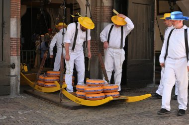 Alkmaar, Hollanda - 22 Nisan 2022: Bu tüccar pazarının Alkmaar, Hollanda 'daki geleneksel Peynir Pazarı' nda nasıl işlediğinin gösterimi sırasında kimliği belirsiz kişiler